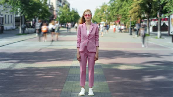 Time Lapse of Cute Blonde Standing in Urban Street Alone Among Crowd of People