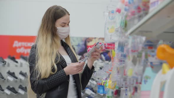 Female in Medical Mask Buying Nipples for Babies in Shopping Center