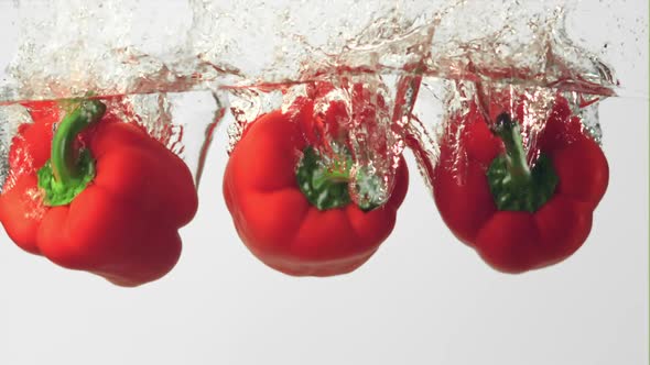 Super Slow Motion Red Pepper Falls Under the Water with Splashes