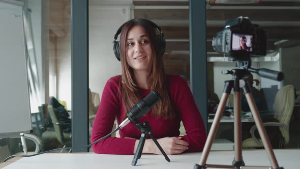 Young Woman Vlogger or Blogger Records Video Podcast on Camera in Microphone Talking