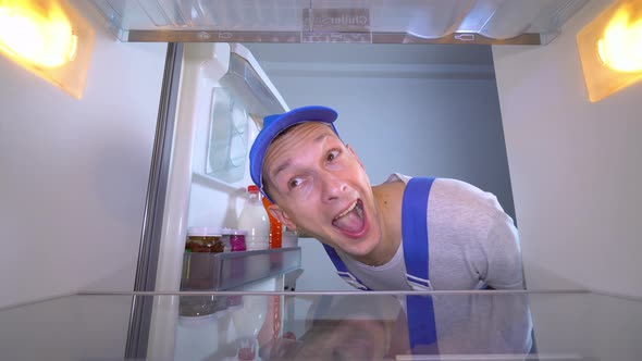 refrigerator repairman opens door and shows class by giving a thumbs up.