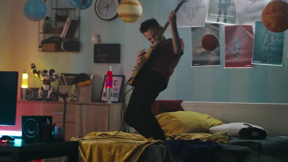 Teen Rocker Performing on Bed in Evening