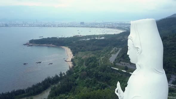 Aerial Round Motion White Buddha Statue Head Against Hills