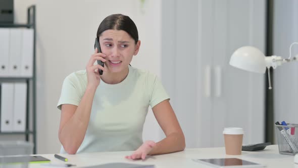 Angry Woman Talking on Phone at Work