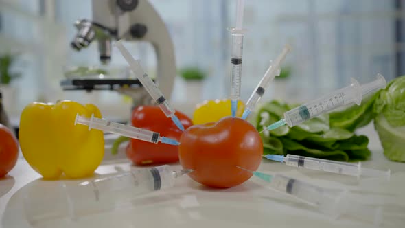 the Idea of GMO Vegetables on the Table Closeup Syringes