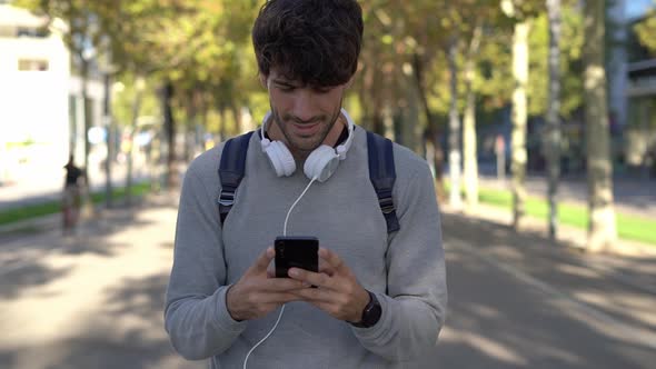 Man with backpack and smartphone in the city