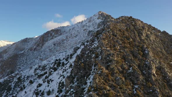 View of mountain with snow on the shady side as sun melts the sunny side