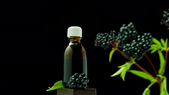 Medicine In A Jar On A Black Background. Black Elderberry In A Medical Bottle. Homeopathy