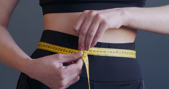 Sporty Woman Measuring Size of Her Waist, Close Up