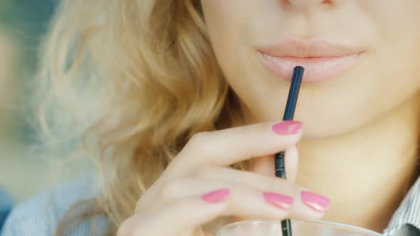 The Lips of a Young Sensual Woman Drinking a Cocktail From the Tube, Smiling