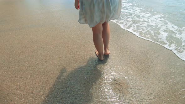 Sandy Seashore with a Lady Walking Along It