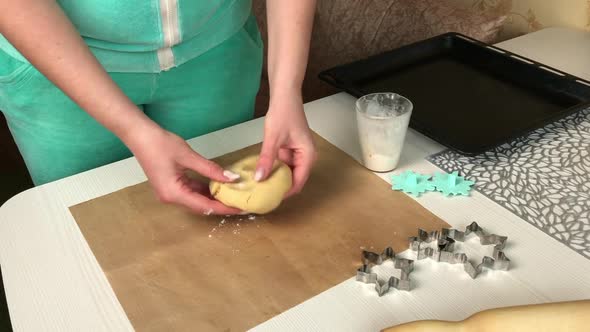 A Woman Sprinkles Flour On A Lump Of Dough.