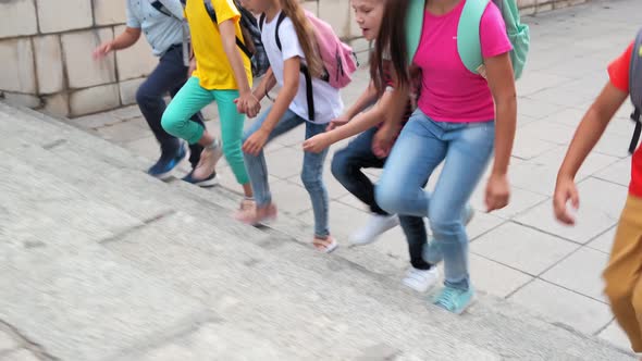 Little Pupils with Schoolbags Run Up Large Stone Stairs