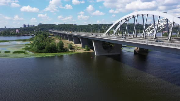 Panoraming Shot of the Darnytsky Bridge Across the River Dnipro in Kyiv in the Afternoon Sunny Day