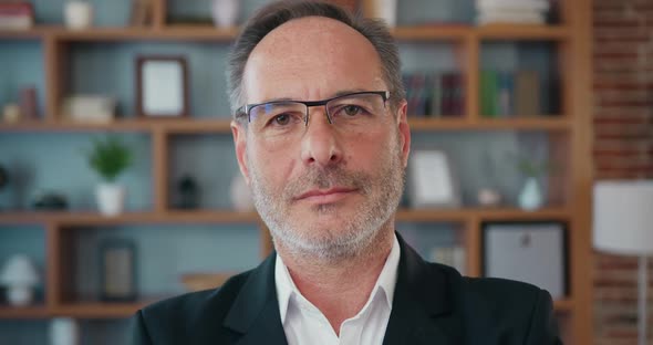 Mature Businessman Looking at Camera Standing in Office.