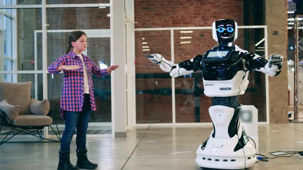 A Girl is Teaching a Cyborg to Do Exercises