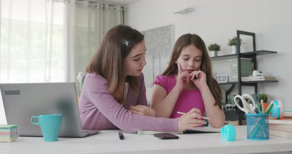 Girl helping her younger sister with her homework