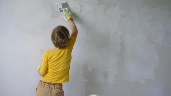 A Boy is Applying Putty to the Wall