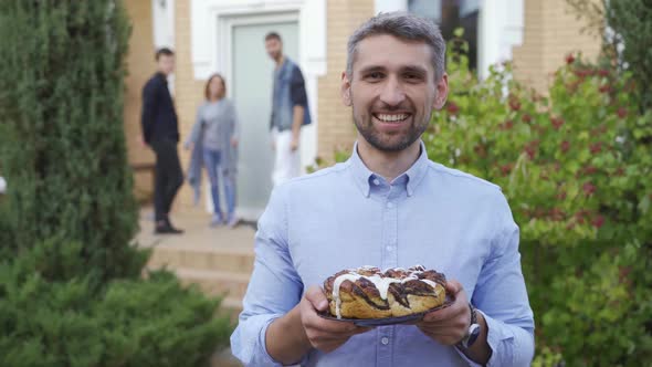 Smiling Caucasian Man Standing with a Cake and Smiling