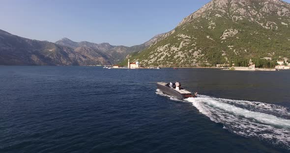 Motor Boat Sails on the Sea Against the Backdrop of Green Mountains and Islands