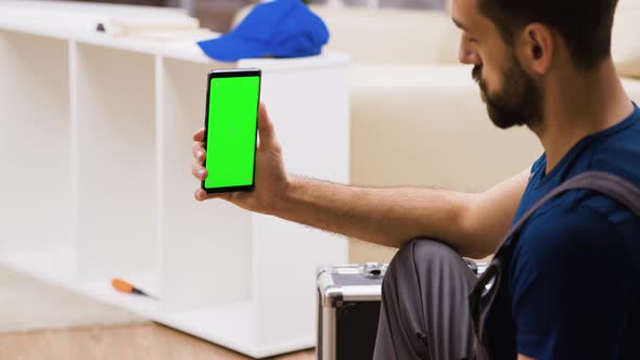 Dolly Shot of Worker in Coverall Looking at Phone with Green Screen