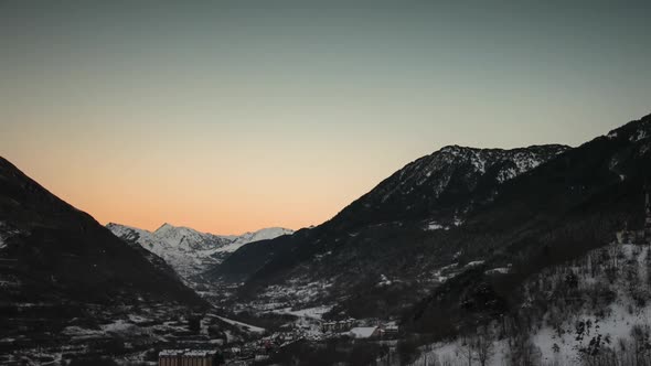 TIME LAPSE - Town in a valley in the Pyrenees, day to night, wide shot tilt down