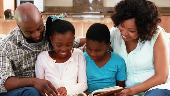 Family reading a book in living room 4k