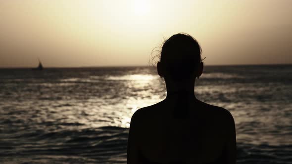 Silhouette of a Beautiful Young Woman Looking at the Sunset in the Ocean Africa