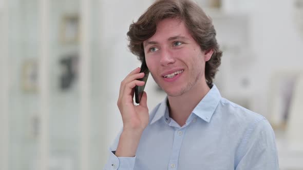 Portrait of Cheerful Young Businessman Talking on Smartphone