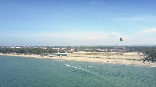 Aerial View Colourful Parachute Over Ocean with Motorboats