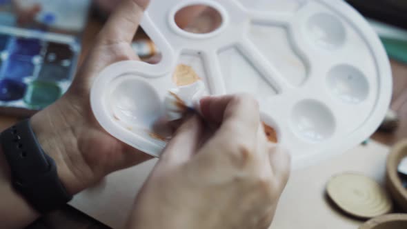 Person's Hands Rubbing Dirty Art Palette with Wet Wipes