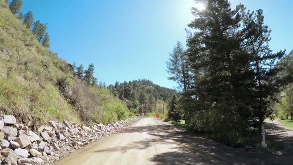 POV point of view -Driving on mountain dirt road in the Spring.