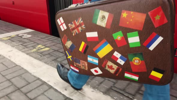 A Man with a Vintage Suitcase Is Walking on a Railway Platform.