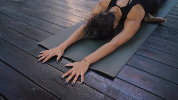 Young Woman in Sportswear Practicing Yoga Alone on Wooden Deck