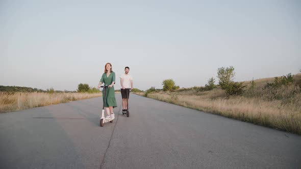 Couple in Love Riding on Electric Scooters to Camera and Having a Fun on the Way