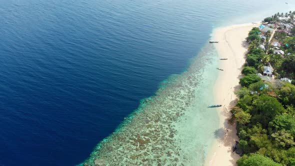 Aerial: flying over tropical Hatta island white sand beach Banda Islands Maluku