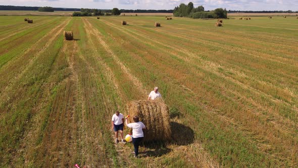 Family with Son Run Around Haystack and Play Aerial View