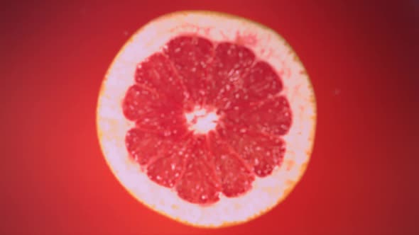 Fresh Half Grapefruit Falling in Juice in Slow Motion