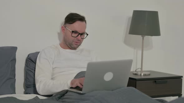 Casual Man Having Back Pain While Using Laptop in Bed