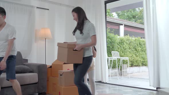 happy Asian family moving to new house with cardboard boxes and arrange the house.