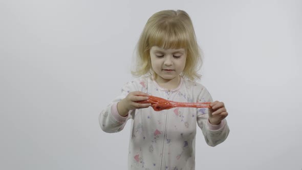 Kid Playing with Hand Made Toy Slime. Child Having Fun Making Red Slime