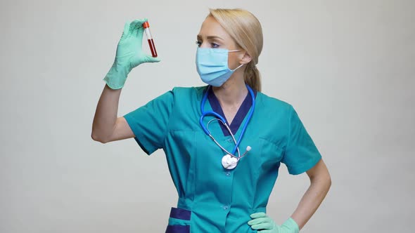 Medical Doctor Nurse Woman Wearing Protective Mask and Latex Gloves - Holding Blood Test Tube