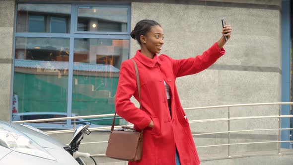 African American Girl Taking Selfie with Electric Car That Is Charging. Electrical Car Recharging