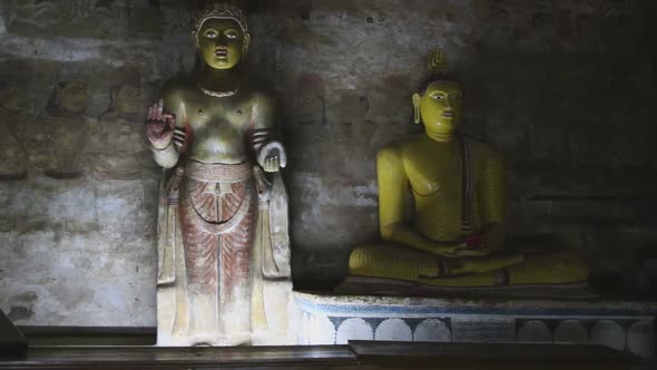 DAMBULLA, SRI LANKA - FEBRUARY 2014: Sitting Buddha and standing Buddha at the Golden Temple of Damb