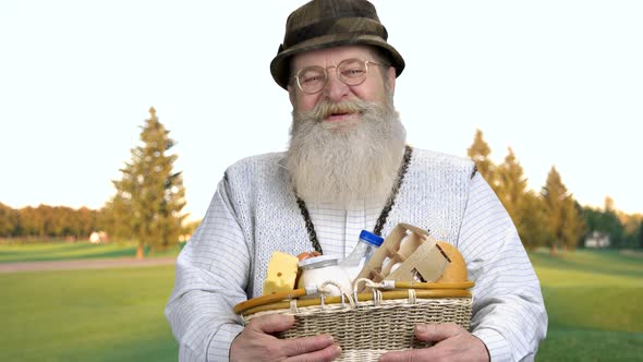 Cheerful Mature Farmer Holding Basket on Healthy Products.