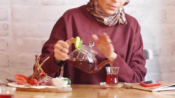 Beautiful Muslim Business Woman in Hijab Drinking Tea in Cafe