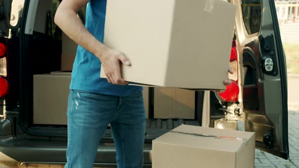 Delivery Worker Bringing Cardboard Boxes From Van to Front Door Entering House