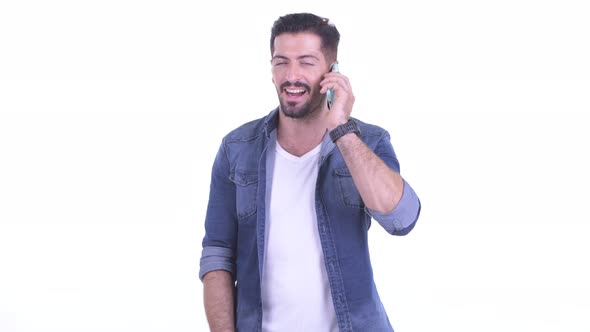 Happy Young Bearded Hipster Man Talking on the Phone