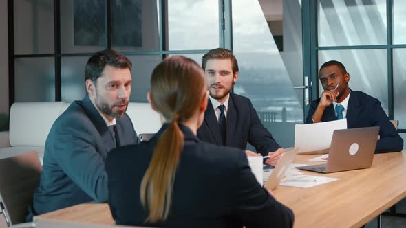 Group of people talking and working at the desk in the office