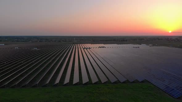 Aerial Drone View Into Large Solar Panels at a Solar Farm at Summer Sunset. Solar Cell Power Plants